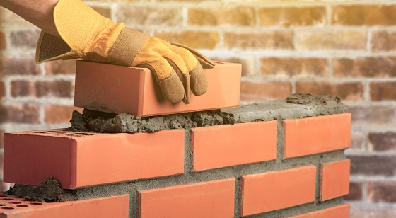 Worker builds a brick wall in the house